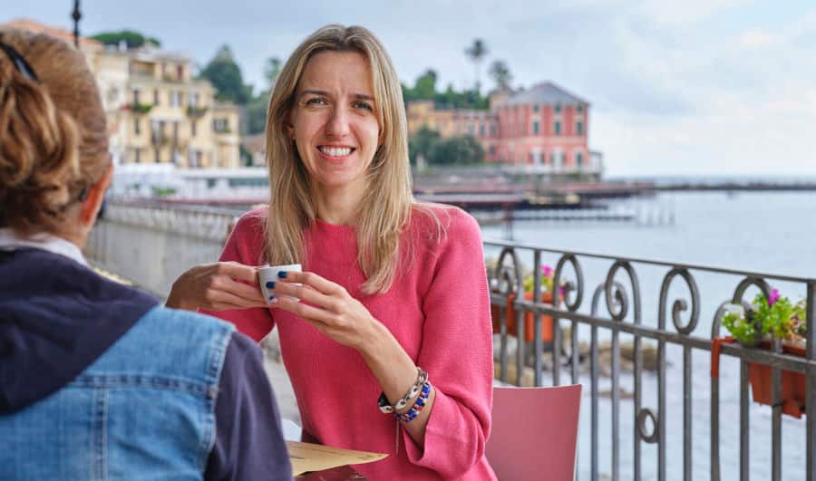  Photo of Elise sitting at a coffee shop. She uses Luja female to manage her bladder symptoms associated with her MS. 