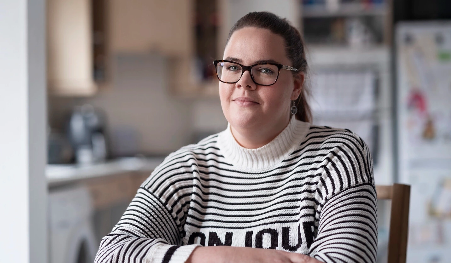 Sarah, an intermittent catheter user living with MS, sits at a table.