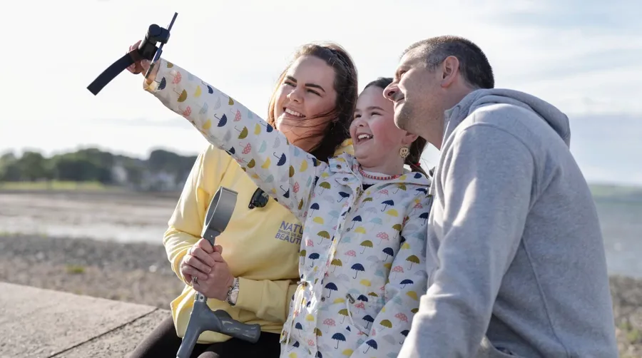 Photo of Sarah and her family taking a selfie together at the beach. It took Sarah a long time to connect her bladder problems to her MS diagnosis.
