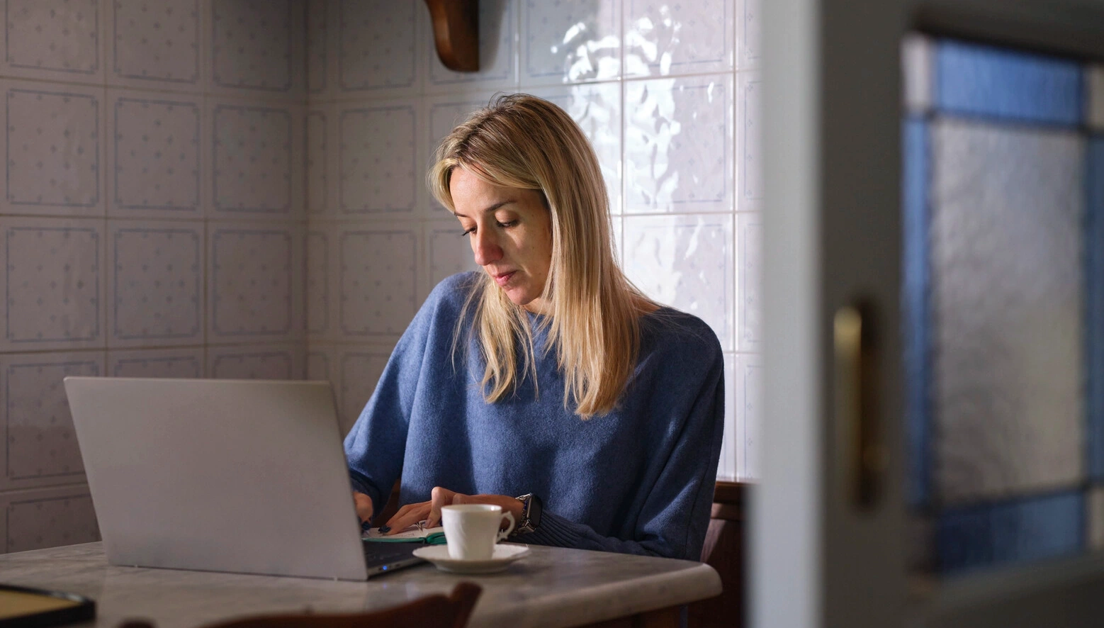 Image of Elisa, who lives with MS, sitting with her laptop. MS can affect the bladder and bowel and may lead to UTIs and/or sexual dysfunctions. 